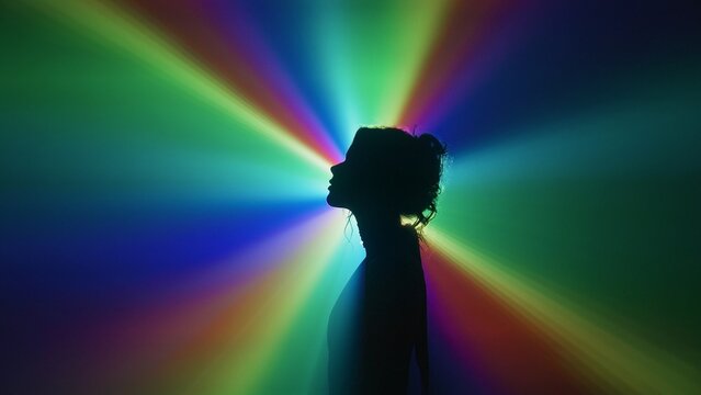 Silhouette of woman in rainbow light burst