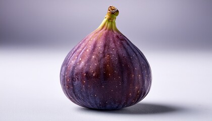 closeup of a ripe fig showcasing its deep purple color and delicate textured skin against a white background