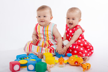Happy Babies Playing with Colorful Educational Toys on White Background &ndash; Smiling Infants in Stylish Outfits Engaged in Learning and Fun, Perfect for Parenting, Early Childhood, or Toy Ads