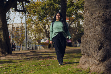 happy young woman in the park walking towards the camera.