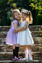  Adorable Little Girls Dressed as Princesses Hugging Outdoors. Childhood friendship. Sweet best...