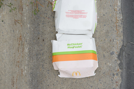 discarded food box for McChicken (and oddly MacPoulet) on the ground