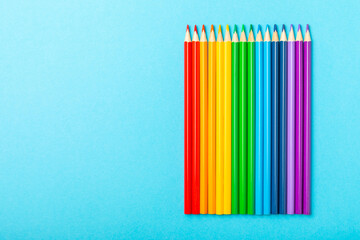Colored pencils on a bright colored background. Equipment for coloring. Stationery for...