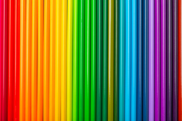 Colored pencils on a bright colored background. Equipment for coloring. Stationery for...