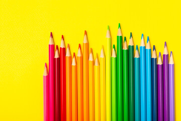 Colored pencils on a bright colored background. Equipment for coloring. Stationery for...