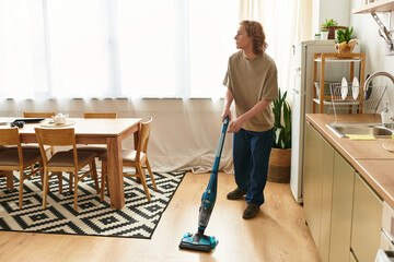 Handsome young man tidying up his home environment with focus and care