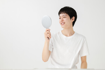 鏡を見て微笑む男性