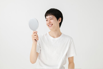 鏡を見て微笑む男性