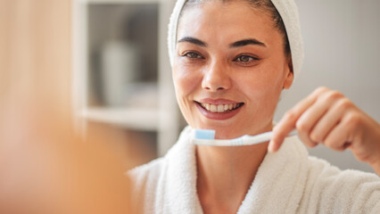 Young woman brushes her teeth	