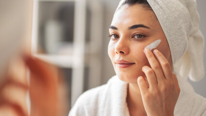 Reflection in a mirror beautiful woman making cosmetic skin care	