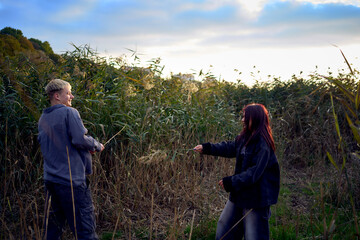 15-year-old teenage couple in love playing in  reeds at sunset