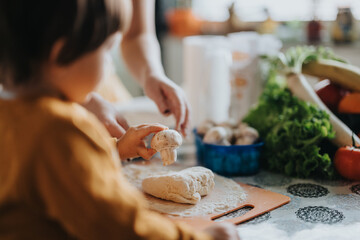 A warm and cheerful moment in the kitchen with a child and adult working together to prepare food...