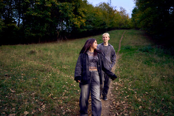 Fototapeta premium two 15-year-old teenagers in love play, hug, spend time together in an autumn park