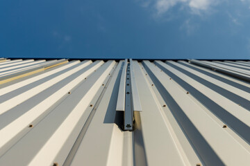 Vue sur une façade en tôle crème équipée de supports métalliques prêts à accueillir des...