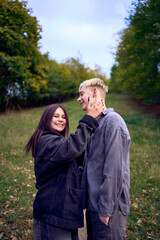 two 15-year-old teenagers in love play, hug, spend time together in an autumn park