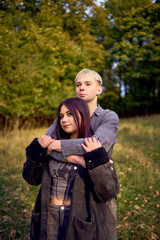 Fototapeta premium two 15-year-old teenagers in love play, hug, spend time together in an autumn park
