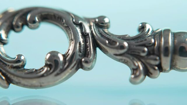 Elegant ornate silver design, macro detail on a light blue background