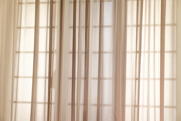 Sunlight filtering through sheer curtains in minimalist room interior