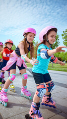 Happy children energetically rollerblade in a park on a sunny day. Concept of early sports...