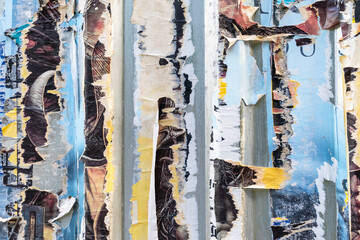 Colorful torn posters on urban wall creating abstract art