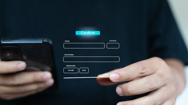 Hand holding smartphone and credit card with online payment form, digital transaction, secure mobile payment, and credit card information confirmation concept.