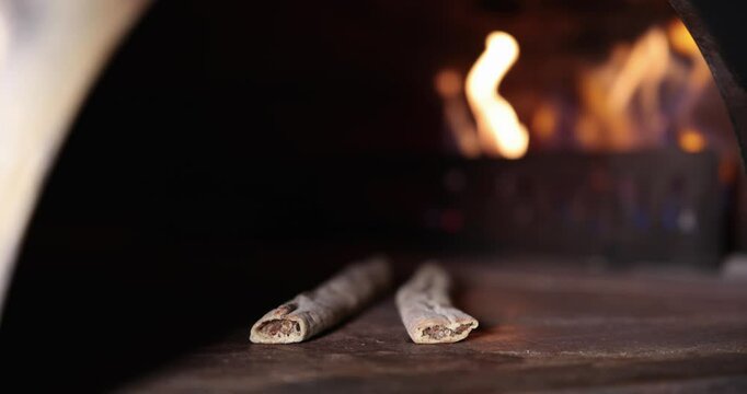 Two Samsun Pide in the Foreground Inside a Wood-Fired Oven with Flames in the Background &ndash; 4K Slow Motion