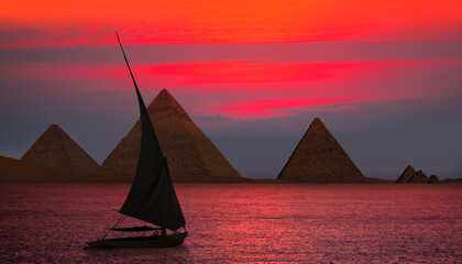 Beautiful Nile scenery with traditional Felluca sailing boat in the Nile  to Giza pyramids at...
