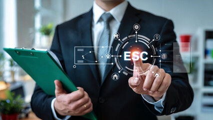 Businessman interacts with a futuristic digital interface displaying esc acronym and various icons representing business and technology concepts