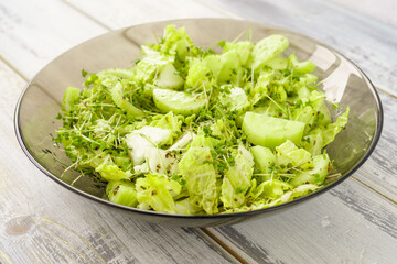 Fresh green microgreen salad on a light blue plate. A natural and organic concept for healthy eating and spring or summer food presentations.
