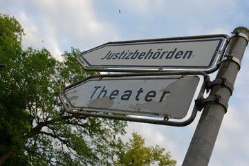 Two signposts in Flensburg point towards the judicial authorities and the theater