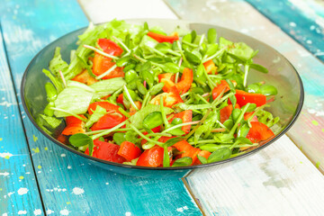 Fresh vegetable salad with micro greens and red pepper in a transparent bowl. Concept of healthy nutrition using for cookbook or food blog.
