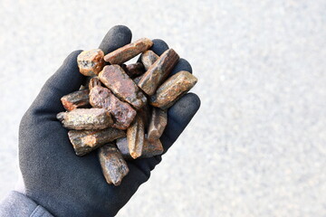 Andalusite held in hand with protective glove. Mined to manufacture high temperature refractory,...
