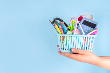 Back to school sale and shopping concept. Variety of school stationery in shopping basket pencils,...