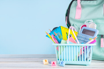 Back to school sale and shopping concept. Variety of school stationery in shopping basket pencils,...