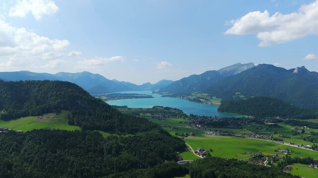 Aerial: Lake Wolfgang and Strobl am Wolfgangsee in the Salzburg Alps region at midday in Austria, orbit drone shot