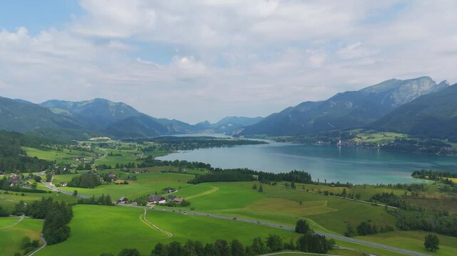 Aerial: Lake Wolfgang in the Salzburg Alps region on a sunny summer day in Austria, pull out drone shot