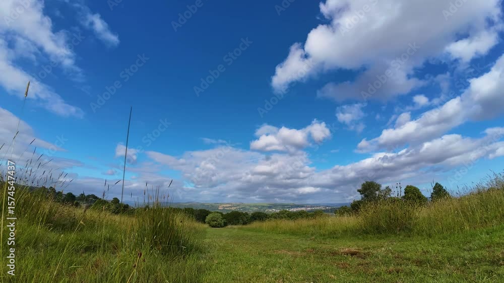 Aufkleber fast timelapse over long grass field on wide angle lens with clouds moving quickly and fading as the
