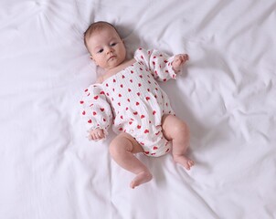 Cute newborn baby lying on bed, top view