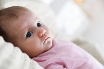 Cute newborn baby lying on bed indoors