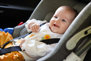 Cute little baby fastened in car seat