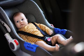 Cute little baby fastened in car seat