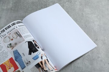 Open magazine on grey table, above view. Mockup for design