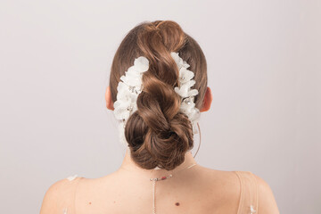 Elegant bridal tiara adorning the meticulously styled hair of a young bride, seen from behind,...