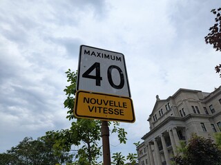Obraz premium Speed limit sign showing “Maximum 40” with an additional yellow plate below reading “Nouvelle Vitesse,” indicating a newly changed speed regulation in a French-speaking area.