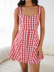 Asian female in red checkered summer dress standing in bright room