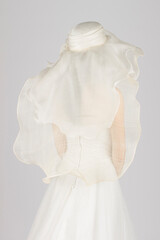 Elegant bridal veil on a young girl, seen from behind, against a soft grey studio backdrop