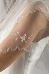 Elegant bridal veil on a young girl, seen from behind, against a soft grey studio backdrop