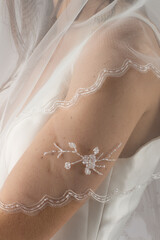 Elegant bridal veil on a young girl, seen from behind, against a soft grey studio backdrop