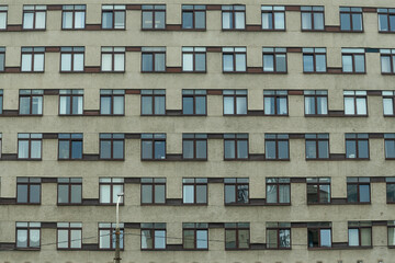 Urban facade with brown windows and reflections. The interplay of light and shadow on a modern...