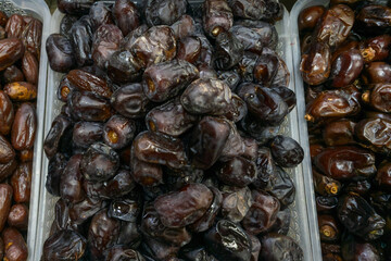 Date fruit on market stall fresh natural tropical healthy snack. Close up of ripe brown dates displayed on rustic market stall symbolizing abundance and natural harvest.